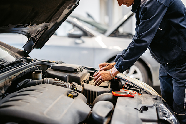 Mechanic testing car battery