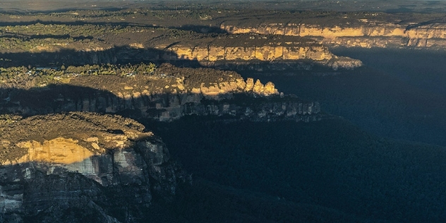 arial view of Katoomba's distinctive rocky cliffs with bushland valley below